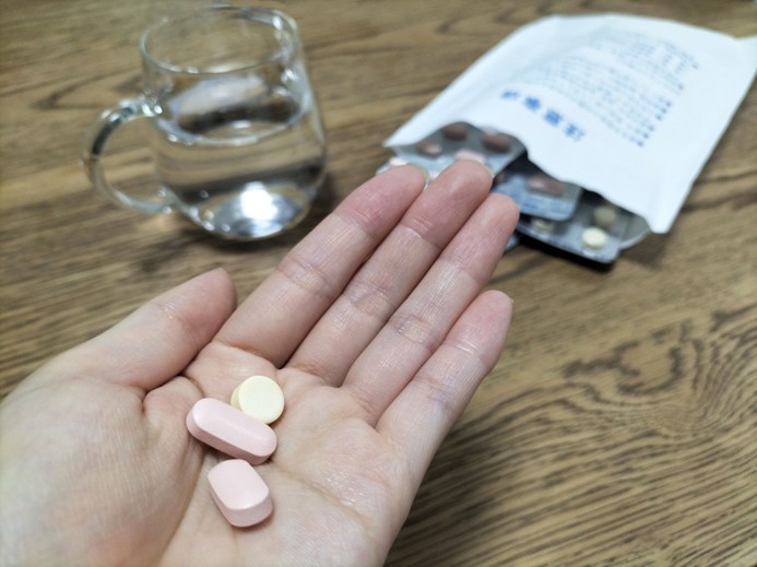 薬を手に取り、服用しようとしている様子